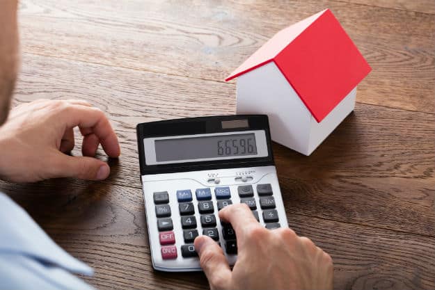 man using calculator | How Does A Property Tax Calculator Work?