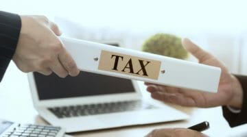 Featured | person holding tax document folder | Are Bonuses Taxed Differently Than Commissions? | Tax Rate on Bonuses | tax rate on bonuses | tax on bonuses