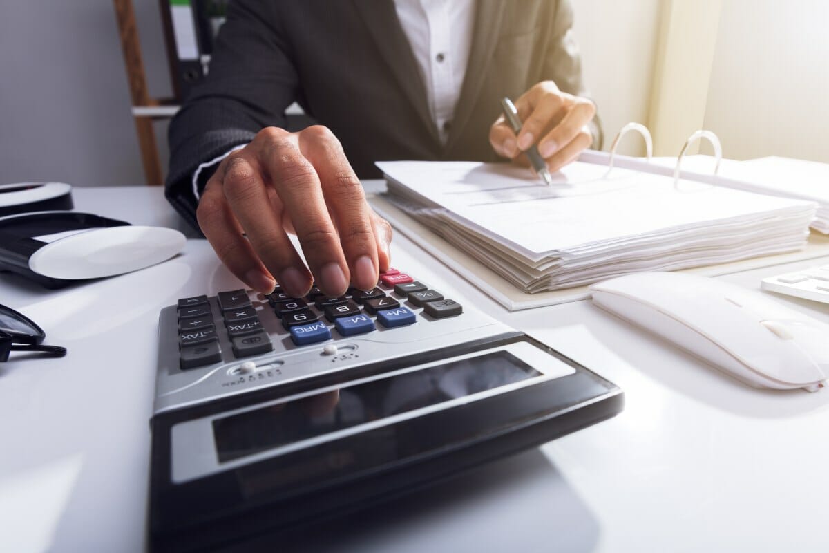 man using a calculator | Key Points To Remember When You Calculate Payroll Taxes