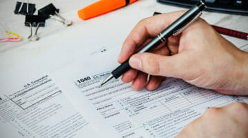 Featured | Man filling US tax form | What Are The Most Common Tax Deductions? | Tax Relief Center | tax deduction