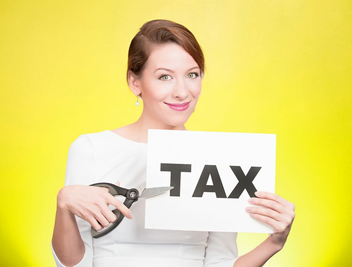 woman holding tax sign | Tax Deductions and Tax Writeoffs Guide | Tax Writeoff Blog Roundup | What Is Tax Deductible?
