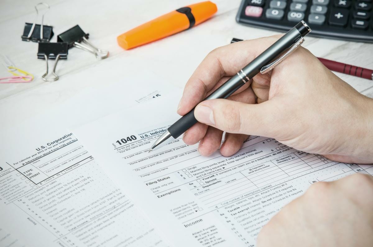 man filling out tax form | Tax Deductions and Tax Writeoffs Guide | Tax Writeoff Blog Roundup | What Is Tax Deductible?