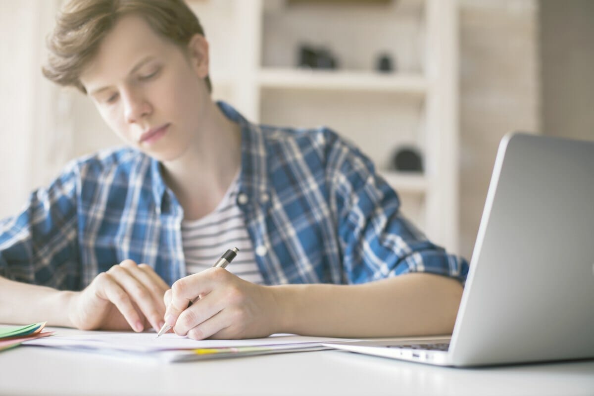 young man writing essay | IRS Scams to Watch For | Real Life IRS Tax Scam Stories