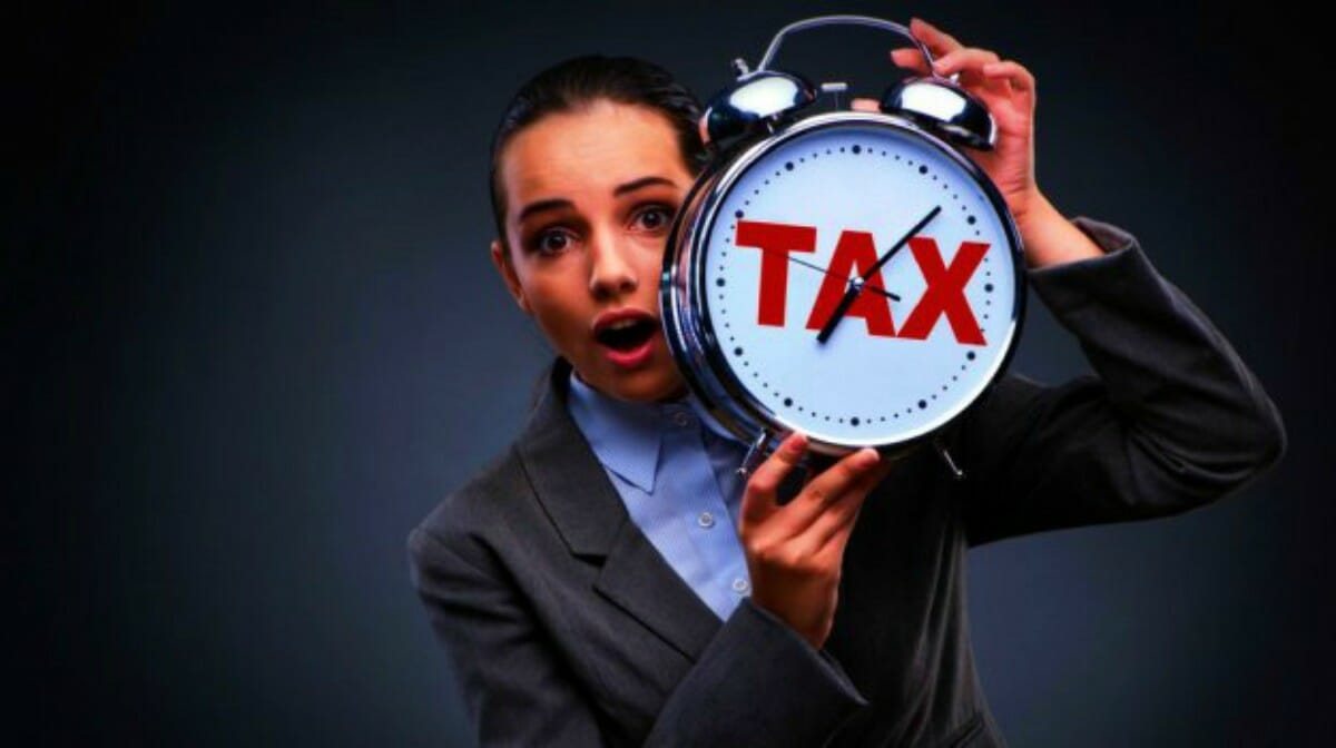 businesswoman with tax clock | How To File Back Taxes