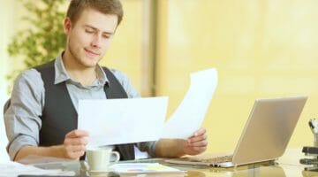 Feature | attentive businessman working comparing paper documents | Filing As Head Of Household | FAQs