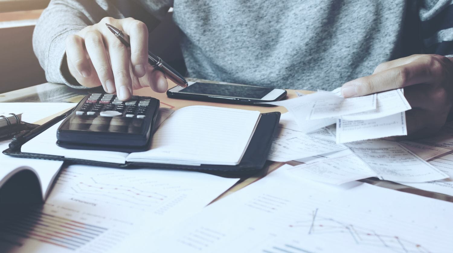 Feature | Man using calculator and calculate bills in home | Standard Deduction vs Itemized Deduction | What’s the Difference? | standard vs itemized deduction