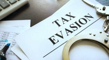Feature | papers about tax evasion desk | What Is Tax Evasion? Understanding Tax Evasion and How It Works | tax evasion