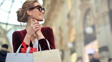 Feature | woman holding shopping bags | Holiday Shopping Tips – How to Get More For A Lot Less