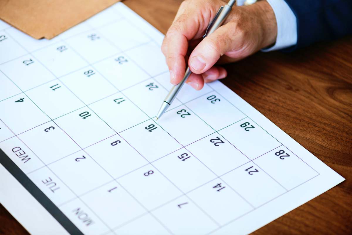person pinpointing pen on calendar | What To Do When You Owe Back Taxes