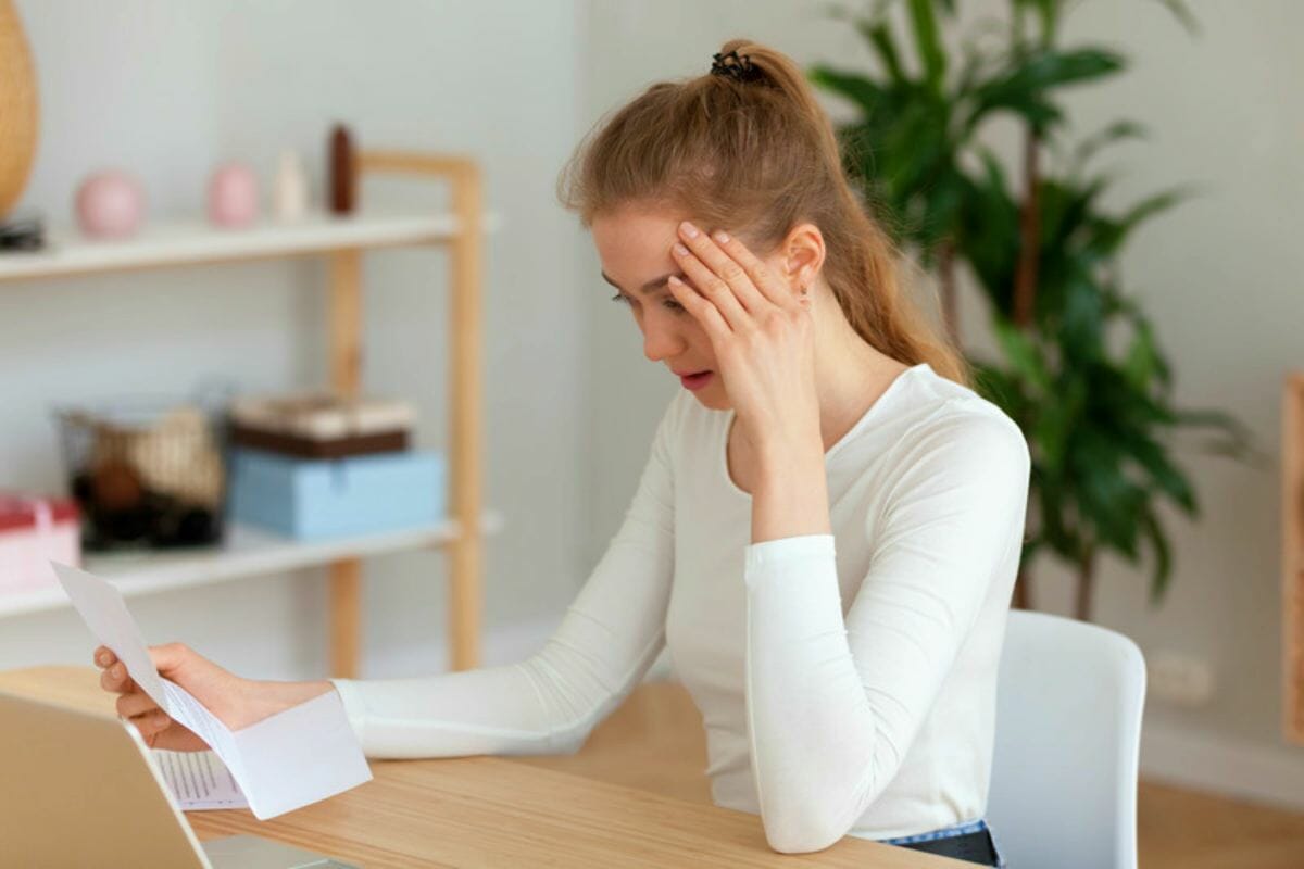 frustrated millennial woman sitting desk office | Types Of IRS Letters and Notices and What They Mean | irs notice