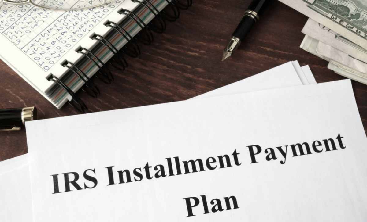 IRS Installment Plan Document pen and notes and money in the table | Things NOT To Say To The IRS If You Owe Back Taxes