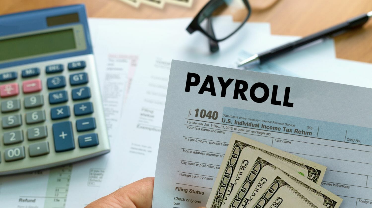 Feature | businessman holding payroll | How To Negotiate Unpaid Employer Payroll Taxes | payroll taxes