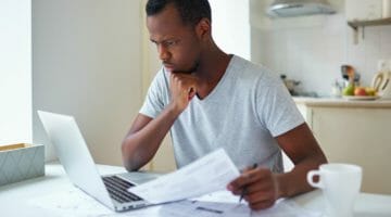 Feature | serious african man looking at laptop | A Guide to State and Federal Lien Release and Withdrawal | release of lien form
