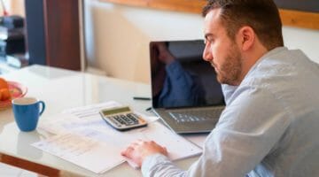 Feature | man calculating bills | Using The IRS First Time Abatement Strategically To Reduce Penalties | first time abatement