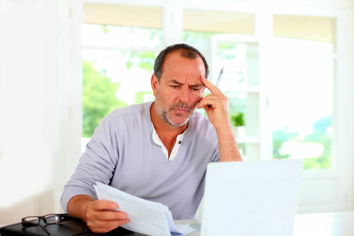 senior man looking at documents | Tax Worries You May Have And The Solutions For Each [FAQs]